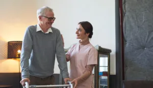 Auxiliar de enfermería asistiendo a una persona mayor